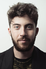 Fototapeta premium Handsome Young bearded man headshot. Portrait of a guy with Rembrandt light.