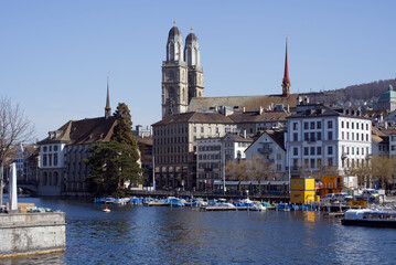 Fototapeta premium Old town of Zurich with church Grossmünster (great minster) and river Limmat in the foreground. Photo taken April 1st, 2021.