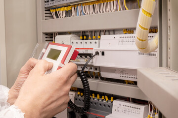 The electrician engineer programs the electrical control circuitry of the electrical system. Smart home.