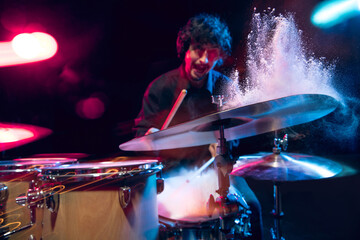 Fototapeta na wymiar Drummer's rehearsing on drums before rock concert. Man recording music on drumset in studio