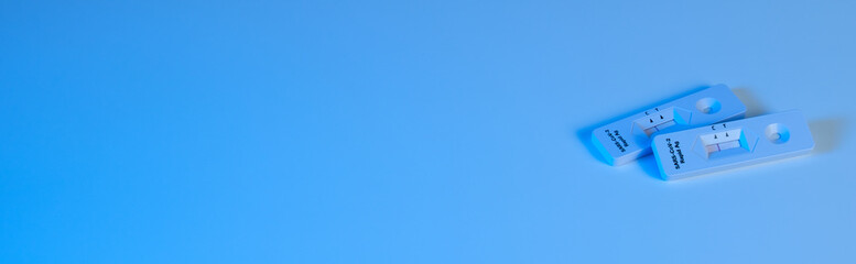 Deko / Banner / Quer: Rechts zwei Antigen Schnelltest COVID-19 (2019-nCoV - coronavirus / SARS-CoV-2 virus / viral disease): Rapid Test