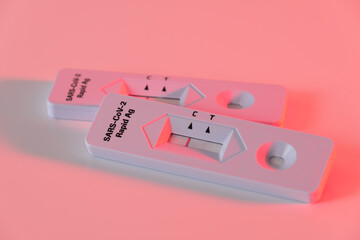 Zwei Antigen Corona-Schnelltest COVID-19 (2019-nCoV - coronavirus / SARS-CoV-2 virus / viral disease): Rapid Test bei r&ouml;tlichem warmen Licht