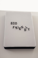 Zero waste concept, pros and cons. Black letters on a peg board with message text Eco friendly on white background. Flat lay.