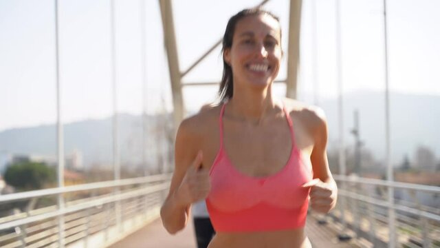 Happy woman jogging on bridge with friends