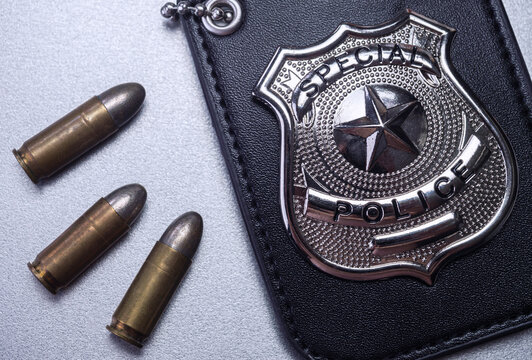 Police badge next to bullets, concept image