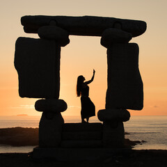 silhouette of a person sitting on a rock