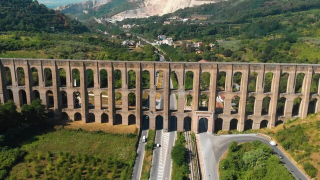 Aerial view. The Aqueduct of Vanvitelli, Caroline. Valle di Maddaloni, near Caserta Italy. 17th century. Large stone structure for transporting water. Viaduct. Road, freeway with vehicle traffic.