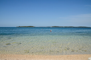 Exotic beach with sand. Soft sea waves on beautiful beach with pebbles. Vacation, travel and tourism concept. 