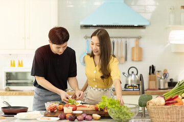 Portrait young couple in love helping to cook In a romantic atmosphere at home with smile face.