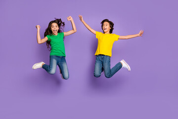 Fototapeta na wymiar Full body photo of children jump up winner wear casual clothes positive mood isolated on violet color background