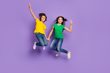 Full length photo of two young kids happy positive smile jump up girl show peace cool v-sign...
