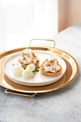 Lemon tarts on a golden plate, selective focus