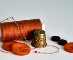 the spool of thread and the needle are on the table