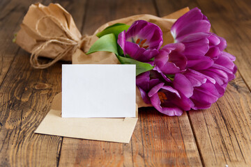 Bouquet and blank card on wooden table