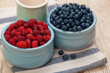 Blueberry and strawberry in ceramic bowls