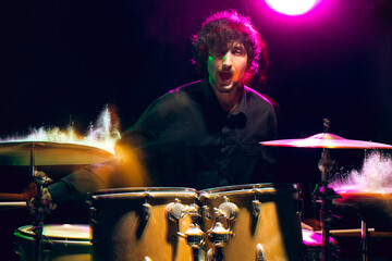 Fototapeta na wymiar Drummer's rehearsing on drums before rock concert. Man recording music on drumset in studio