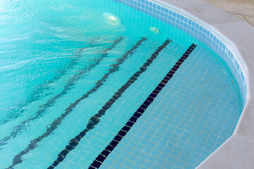 Obraz premium Entrance to the pool with clear turquoise water, tiled steps along the edge. Side view. Summer vacation concept, vacation, safe stay on the water, travel. Horizontal