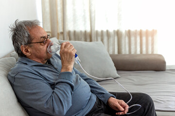 Portrait of senior sick man with grey hair at home inhaling. Portrait of elderly man with flu...