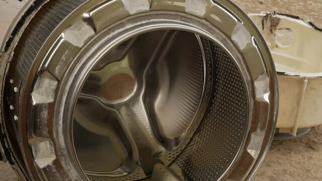 plumber examines rotation of the washing machine drum. repairman professionally fixes a breakdown
