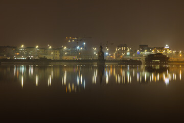 Fototapeta na wymiar Reflection of city lights in the river. Evening illumination of Kiev.