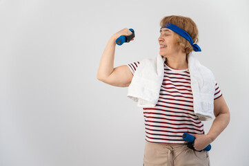 An elderly woman with a blue bandage on her head trains with dumbbells on a white background