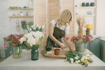 Flower shop. Girl florist makes a beautiful spring bouquet