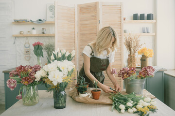 Flower shop. Girl florist makes a beautiful spring bouquet