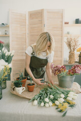 Flower shop. Girl florist makes a beautiful spring bouquet