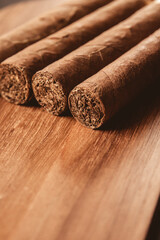 Group of brown cuban cigars on wooden background