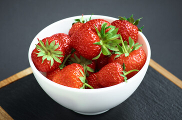 Strawberries on black background. Berries in a plate