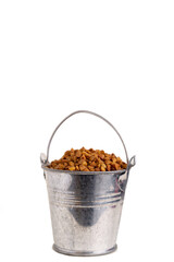 Buckwheat in a metal bucket on a white isolated background.