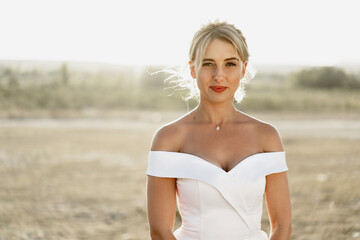 Fototapeta na wymiar Portrait of a beautiful blonde bride in a white dress with bare shoulders