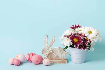 easter blue card with flowers, bunny and pink eggs. background with copy space