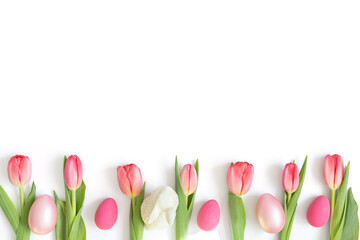 Easter composition with pink tulips, eggs and an Easter bunny isolated on a white background. Copy space, top view, flat lay.