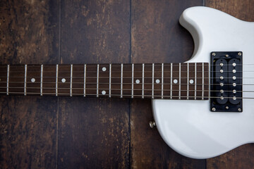 Fototapeta na wymiar Beautiful vintage white electric guitar shape on a wooden background. High quality photo