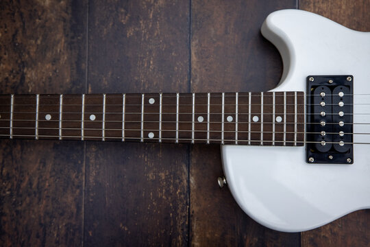 Beautiful vintage white electric guitar shape on a wooden background. High quality photo