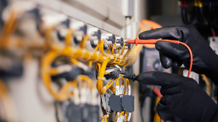 Electrician engineer work tester measuring voltage and current of power electric line in electical...