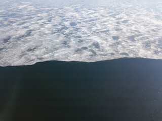 Melting ice edge on the river. Aerial drone view.