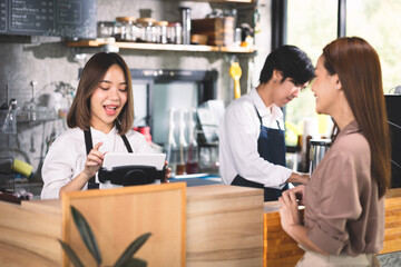A customer orders a hot latte to the barista. Asian Staff coffee shop cafe making hot coffee and serve to customer. Small business sme concept.