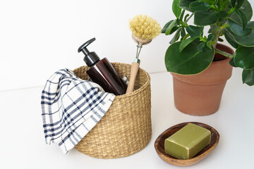 Putzutensilien und eine grüne Seife auf einem weißen Tisch. Nachhaltige Lebensweise,...