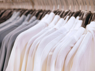 Closeup of white, trendy clothes on hangers in store. fashion wear on clothing rack. cleaning concept