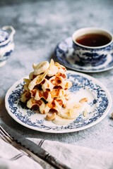 Belgian waffles with banana and honey on a vintage blue plate