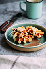 Belgian waffles with banana and honey on a turquoise plate
