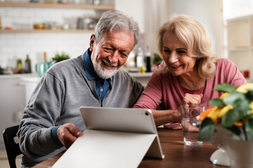 Senior couple having video call. Happy husband and wife talking with their grandkids