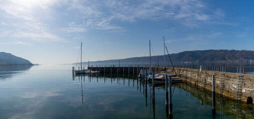 Obraz premium panorama view of ships moored in a small harbor on a calm lake