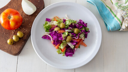 Flat lay view of a fresh mediterranean style salad, placed on top of a white table