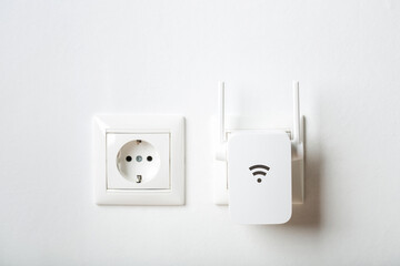 white wi-fi repeater indoors at home in outlet. wireless router - obrazy, fototapety, plakaty