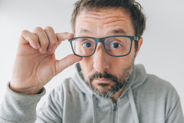 Man trying out new pair of eyeglasses, making funny face