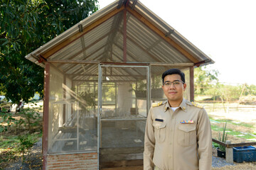 A Thai government officer, Civil servant is standing in front of the greenhouse used to grow plants