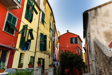 Fototapeta na wymiar Porto Venere,Liguria,Italy. June 2020.Typical secondary alley in the heart of the town: they are called carruggio. Houses with colorful facades and pots with ornamental plants lend a distinctive charm